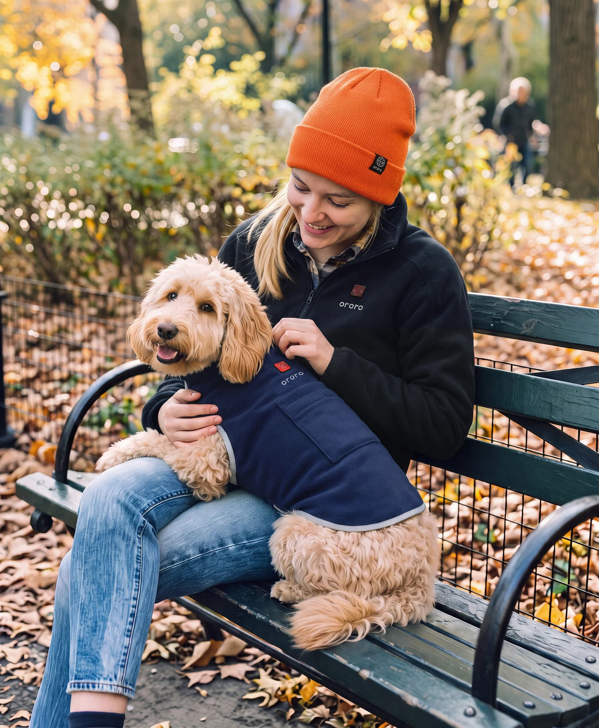 Woman cuddling a dog wearing ororo Fleecywoof 2-Zone Heated Fleece Dog Vest in a park