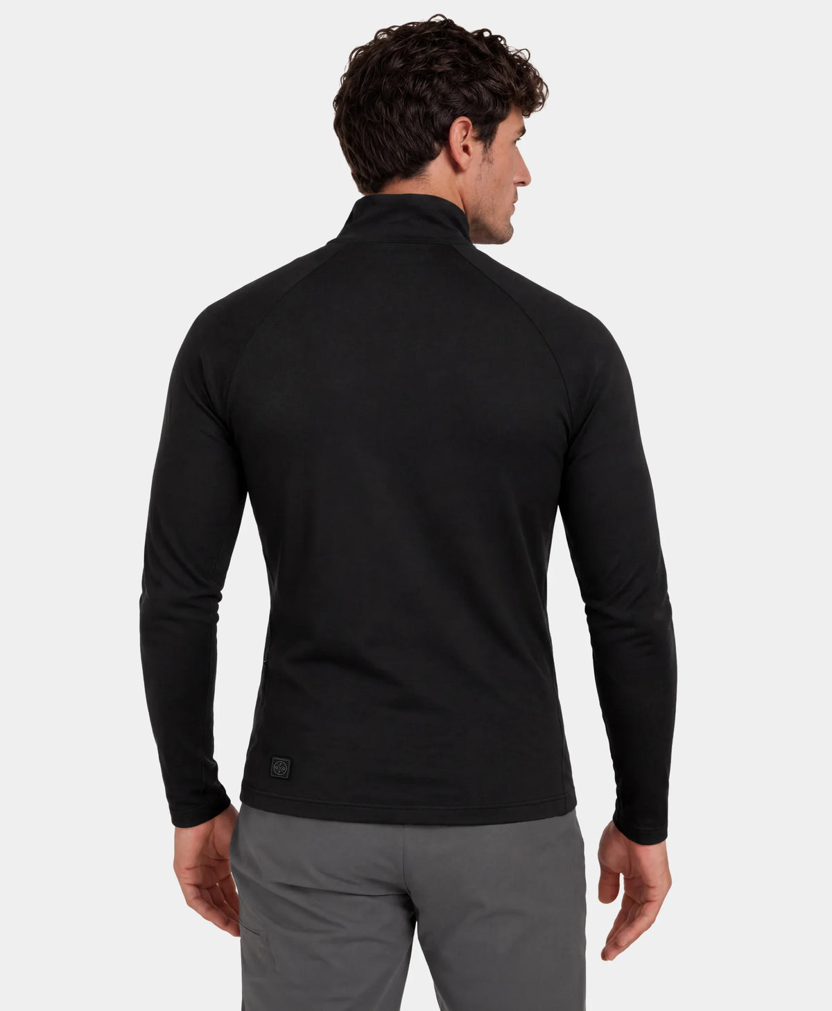 Back view of man wearing black heated base layer top and gray pants