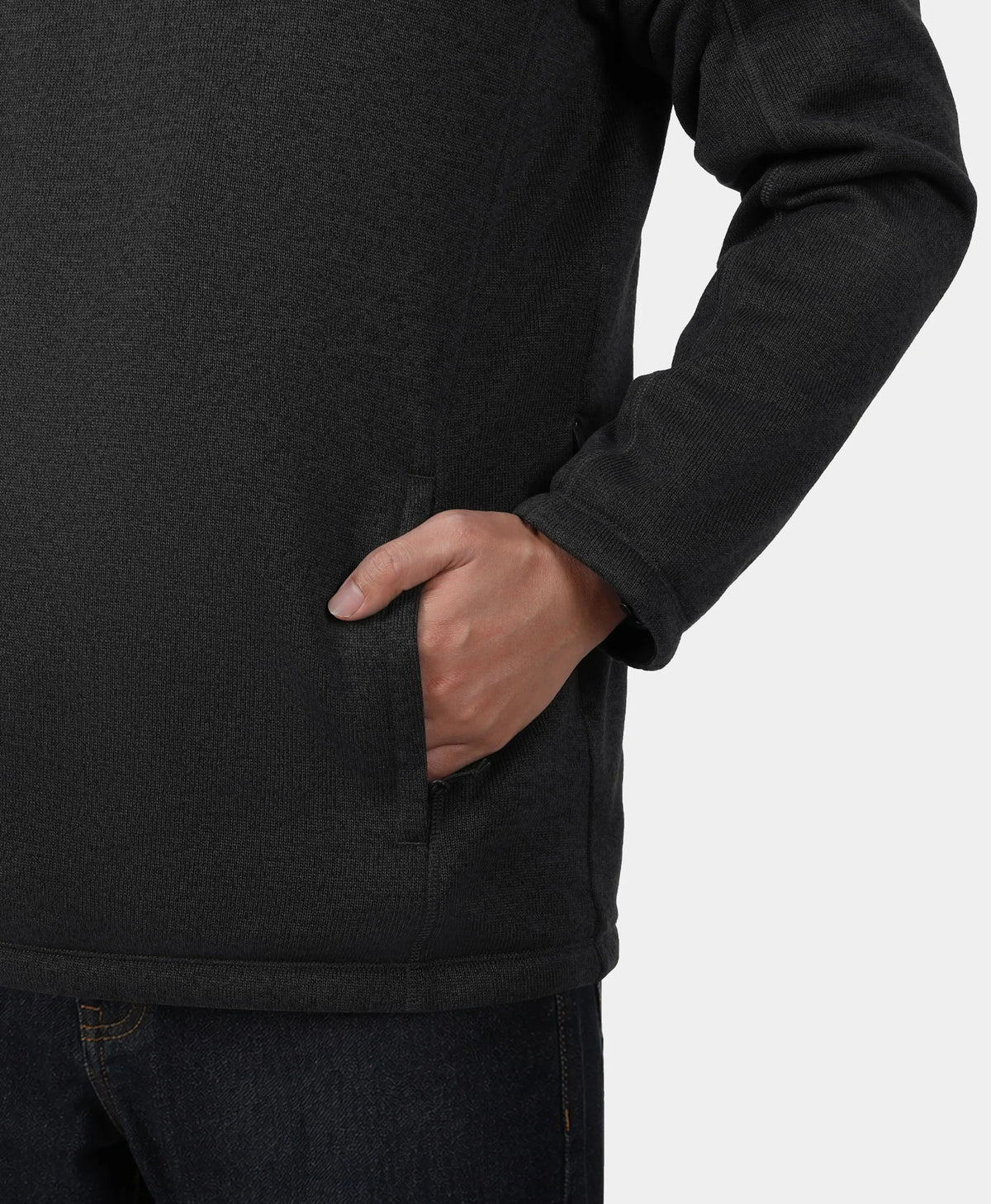 Close-up of a person wearing a dark charcoal fleece pullover with a side pocket