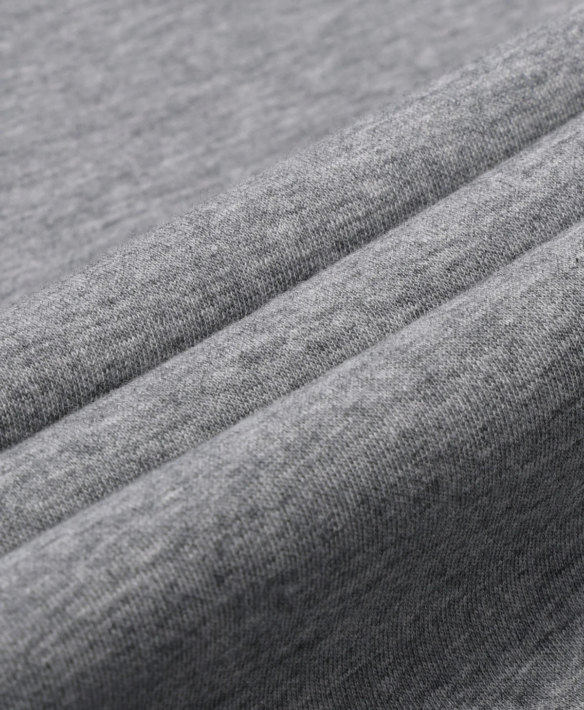 A flecking gray Toasty Unisex 5-Zone Heated Pullover Hoodie, displayed in a macro close-up of draped gray fabric with soft diagonal folds showing a fine woven texture.
